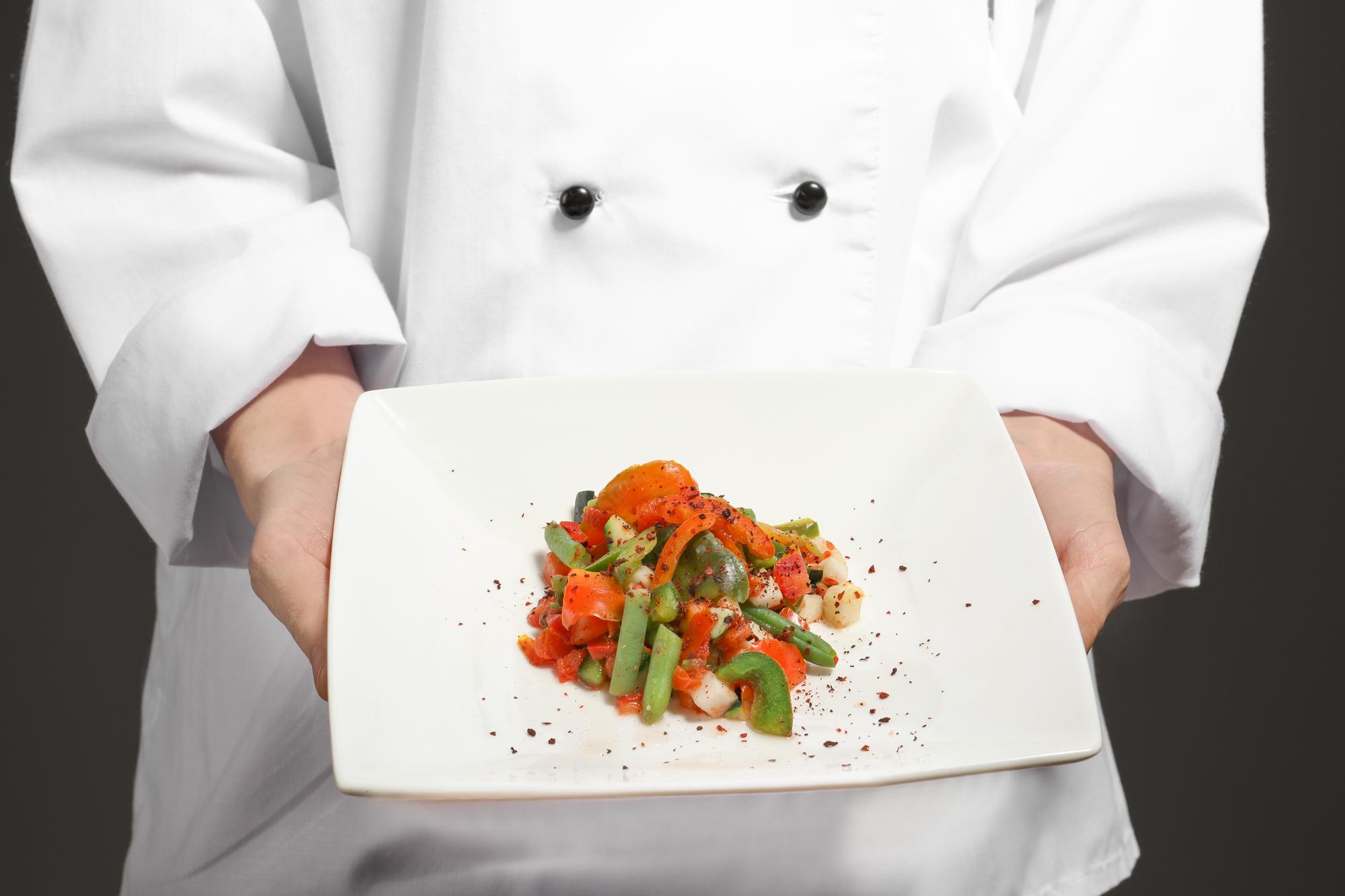 Chef al lavoro in cucina con piatto finito